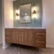 floating bathroom vanity with wood cabinets and blue backsplash